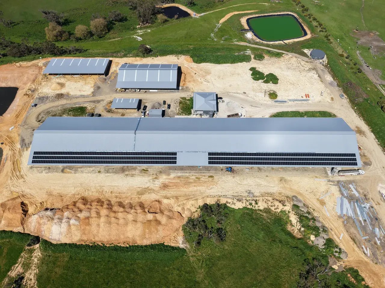 Aerial view of Rockwella Dairy showing the full milking shed, rooftop solar arrays, surrounding buildings and farm dams